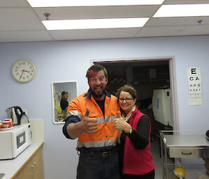 Two expeditioners standing side by side giving the thumbs up to the camera