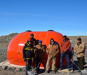 Tradespersons standing in front of the new hut facing camera