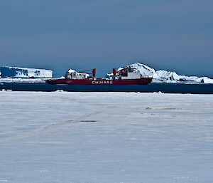 A red ship sitting amongst ice bergs off Davis Station