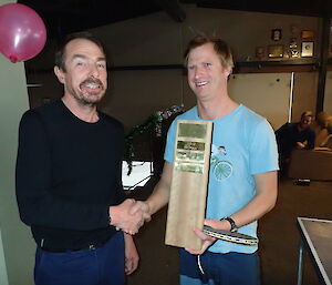 One expeditioner handing over his table tennis trophy won during previous championship to the new winner.