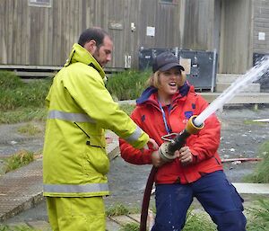 Belinda controlling the jet of water from a fire hose