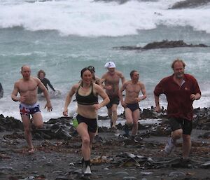 Swimmers exit the water after the first dip on the west beach