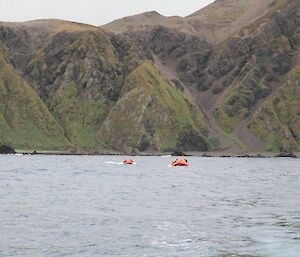 Expeditioners in two rubber boats near the shore