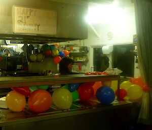 Balloons being stored in the kitchen for the birthday surprise.