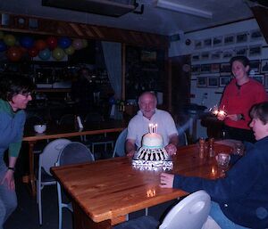 Danny with Eve and two others ready to blow out the candles on the shuttlecock shaped cake