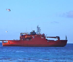 A helicopter picking up a load from the ship