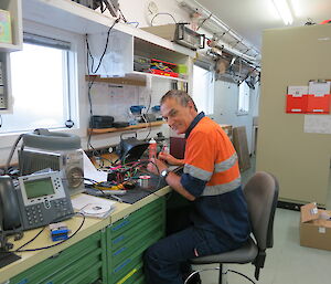 Mango repairing a hut radio