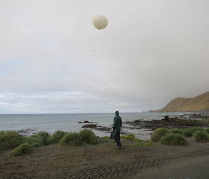 Andrew faces the beach and releases a large weather balloon
