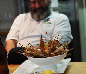 A bowl with skewered meat in front of an expeditioner