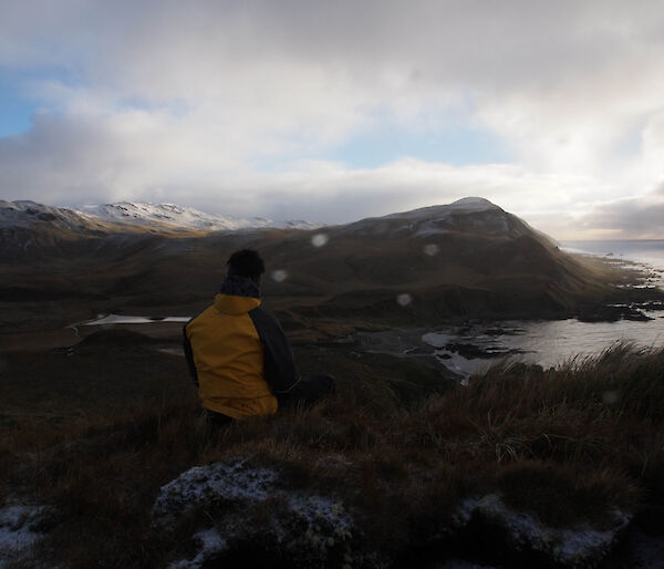 Expeditioner looking out to the horizon and water from Macquarie Island