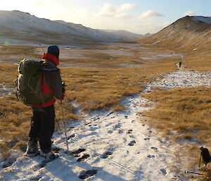 Expeditioners set out on a clear day to go rabbit hunting with landscape in background