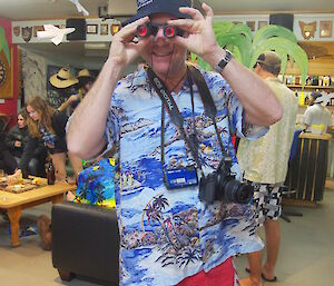 Tom dressed as a beach tourist with cameras