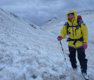 Mango on route to Hurd Point posing with snowy hills surrounding, his brighty yellow jacket a contrast to the stark white and greys surrounding him