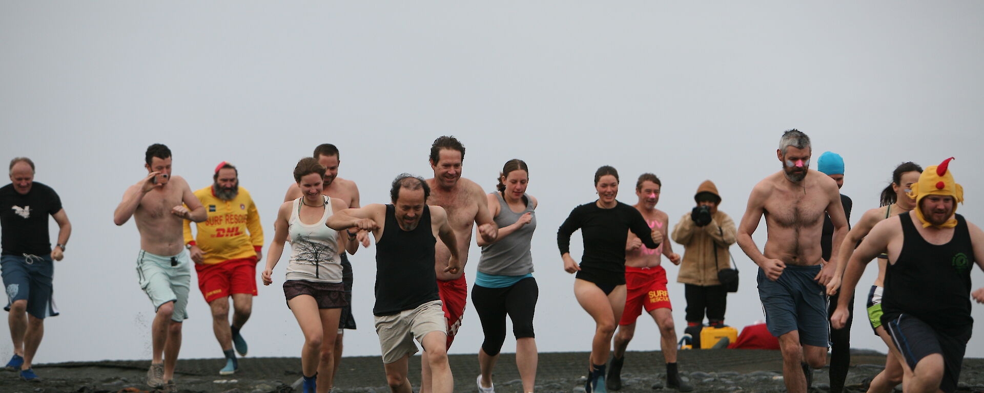 Swimmers run to the water at Macquarie Island for the 2012 Midwinter swim