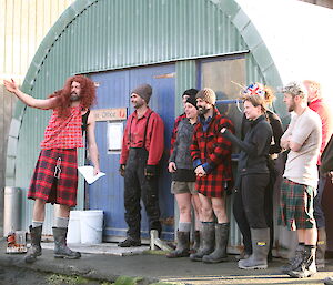 Pete the Scott explaining the haggis throwing comp rules while dressed in red wig and kilt