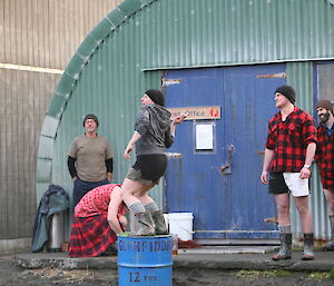 Dana standing on a barrel preparing to toss a haggis