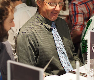 Dave at the dinner table during Midwinter celebrations wearing shirt and tie