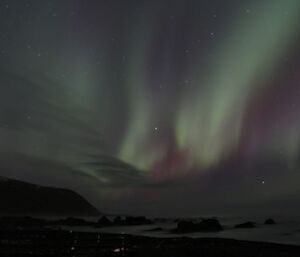 Waves of green and rose fill the western sky over the darkness of the plateau in this photo of the aurora of 18 June 2012