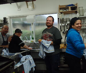 4 expeditioners standing by the sink washing potatoes