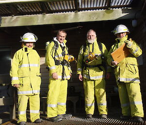 Four expeditioners in yellow suits and helmets