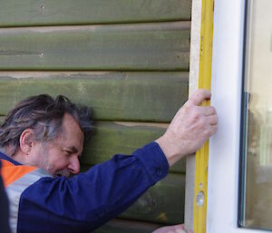 Jim using a level on the window