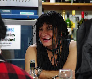 Monica laughing and wearing a wig with tight black braids