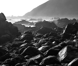 Black and white images of rocky coast with waves in background