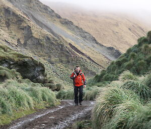 Cam leaving station hiking through grassy hill on Macquarie Island