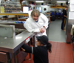 Jim supervisors Maria in the kitchen