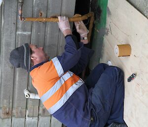 Tom the plumber repairing or insulating a pipe