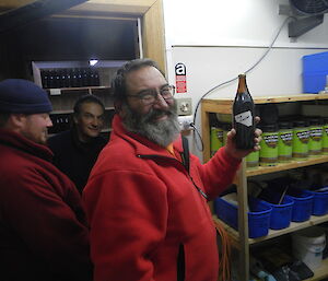 Ray, Chief Brew Master, holds up a bottle of beer