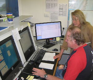 Colin and Narelle standing by the comms console