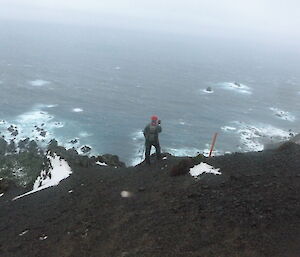 Expeditioner stands near cliff on Macquarie Island