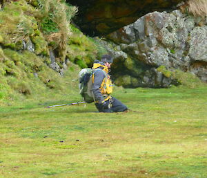 An expeditioner sinks into wet ground on Macca
