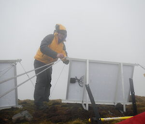 Mango installing solar panels on Mt Waite