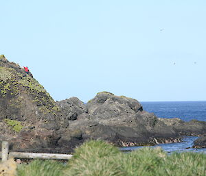 A landscape shot showing land on left and sea on the right. It is a sunny day.