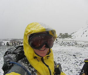 Lauren in full gear poses with snow and penguins in background