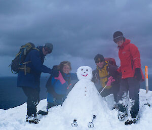 Expeditioners pose with a snowman on Macquarie Island