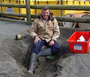 Charles sits on the ground while locating a water sampling point