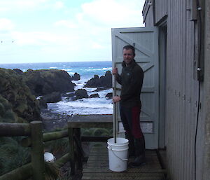 Cameron with mop and bucket just outside Hurd Point hut