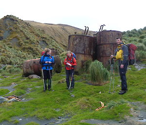 Anna, Jaimie and Richard at the Nuggets posing in front of rusty tanks with green all around