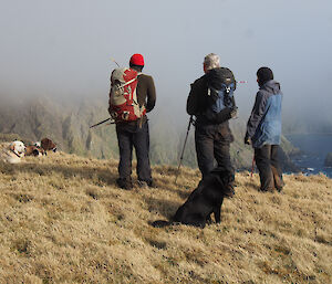 Kelly, Dave and Jane surrounded by dogs and overlooking Macquarie Island’s prehistoric landscapes