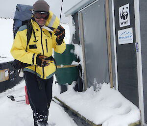 Stu in full gear, surrounded by snow, just outside of a hut