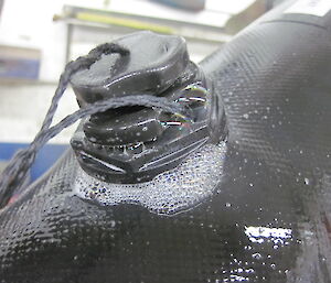 Close-up of leaking under valve on inflatable boat and along seam