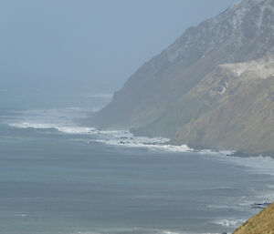 Cliffs and sea are seen through a stromy haze