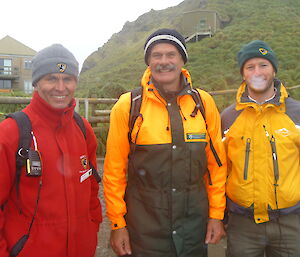 Paul, Peter Mooney and Richard pose together smiling outside on Macquarie Island