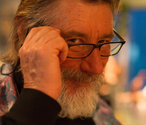 Gaz looks at the camera from over the top thick black-framed glasses