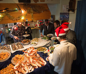 A large buffet surrounded by hungry expeditioners serving themselves