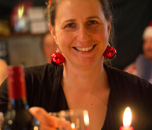 Lauren smiles for camera at Christmas dinner wearing big red bauble earrings and green antlers
