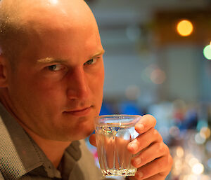 Jack who doesn’t look amused to be having this close-up of his face taken. He holds a water glass